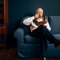 elderly_writer_drinks_coffee_couch_home_office_old_man_glasses_writes_literature_novel_room_with_smoke_inspiration.jpg